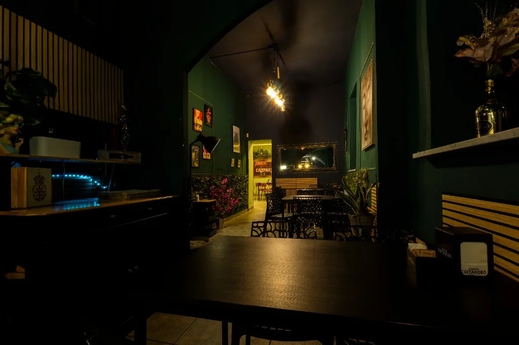 Sala serale con pareti verdi e lampadine appese